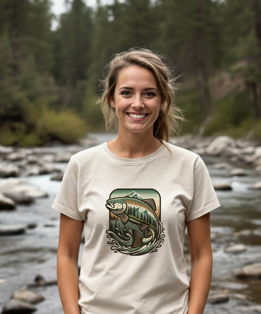 Woman wearing a t-shirt with a nature graphic in front of a forest and stream.