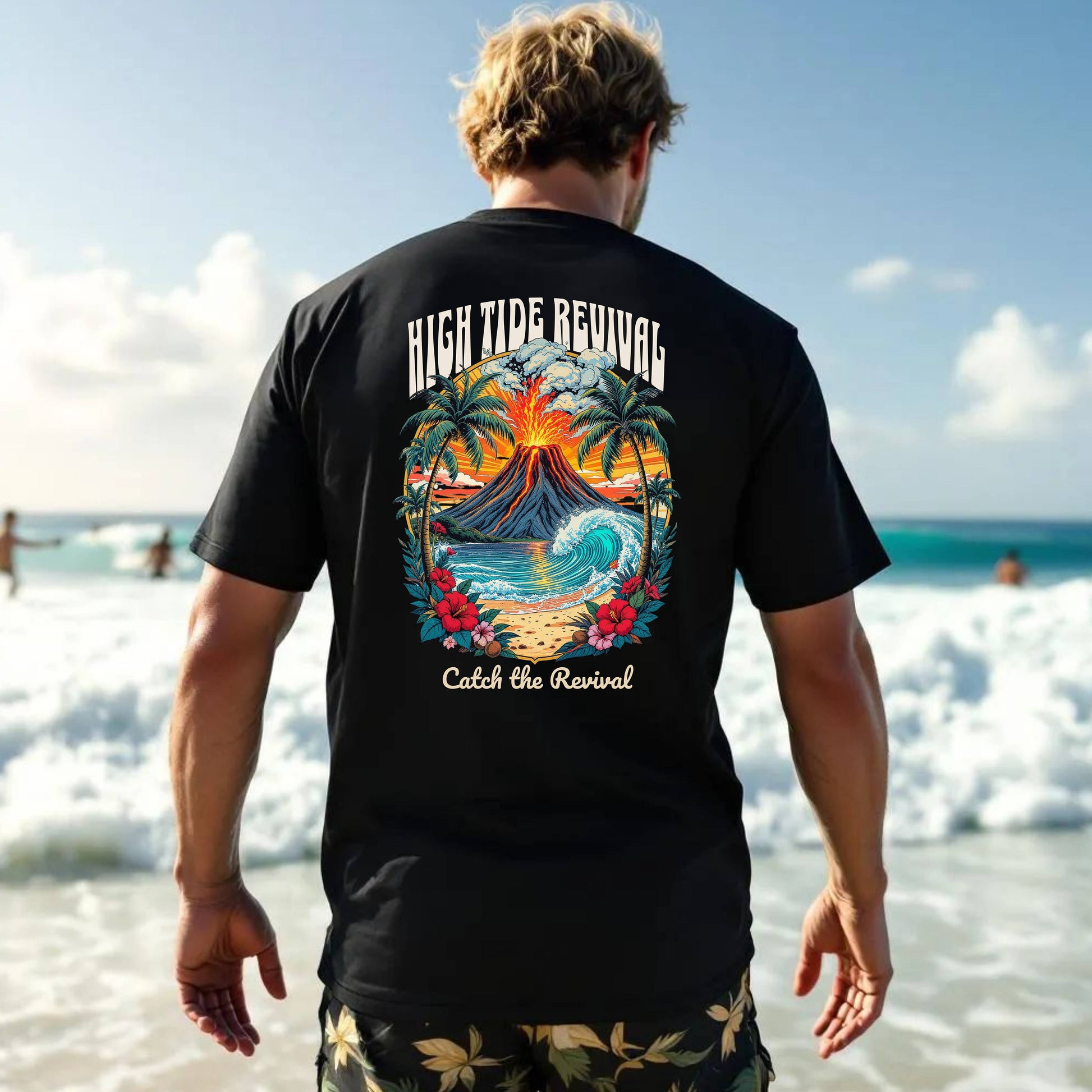 Person wearing a black t-shirt with a colorful graphic and text on the beach