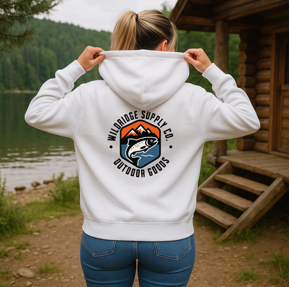 Person wearing a white hoodie with a logo in a natural setting